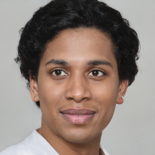 Joyful black young-adult male with short  black hair and brown eyes