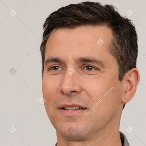 Joyful white adult male with short  black hair and brown eyes