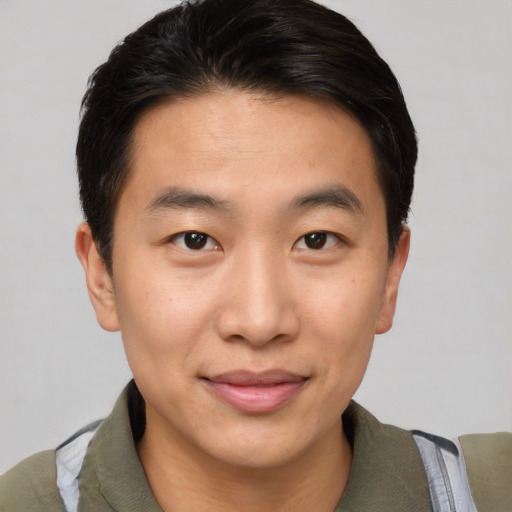 Joyful asian young-adult male with short  brown hair and brown eyes