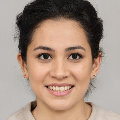 Joyful latino young-adult female with medium  brown hair and brown eyes