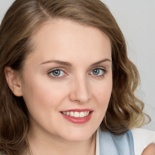 Joyful white young-adult female with medium  brown hair and blue eyes