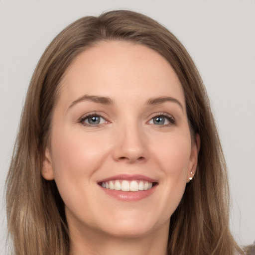 Joyful white young-adult female with long  brown hair and grey eyes