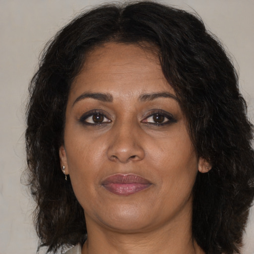 Joyful black adult female with medium  brown hair and brown eyes