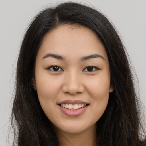 Joyful asian young-adult female with long  brown hair and brown eyes