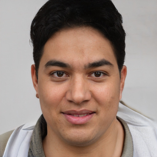 Joyful latino young-adult male with short  brown hair and brown eyes