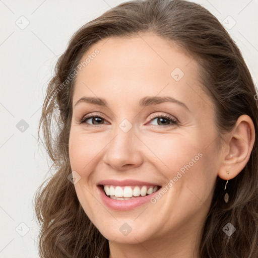 Joyful white young-adult female with long  brown hair and grey eyes