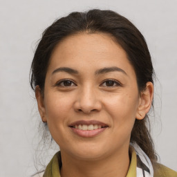 Joyful latino young-adult female with medium  brown hair and brown eyes