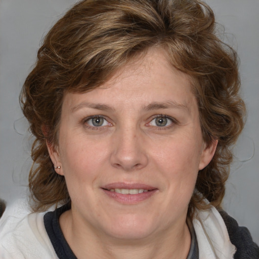 Joyful white adult female with medium  brown hair and blue eyes