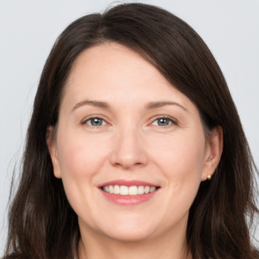 Joyful white adult female with long  brown hair and brown eyes