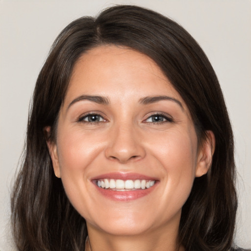 Joyful white adult female with long  brown hair and brown eyes