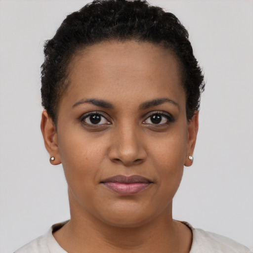 Joyful black young-adult female with short  brown hair and brown eyes