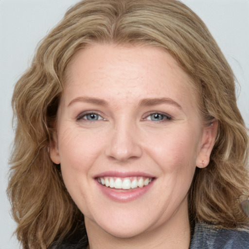 Joyful white young-adult female with medium  brown hair and blue eyes