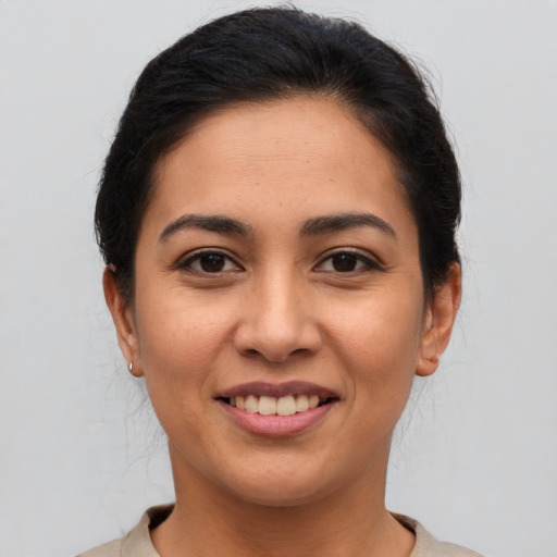 Joyful latino young-adult female with medium  brown hair and brown eyes
