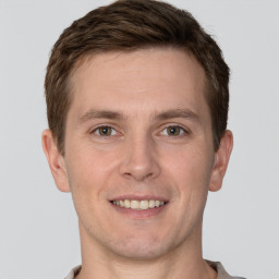 Joyful white young-adult male with short  brown hair and grey eyes