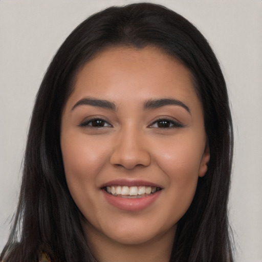 Joyful latino young-adult female with long  brown hair and brown eyes