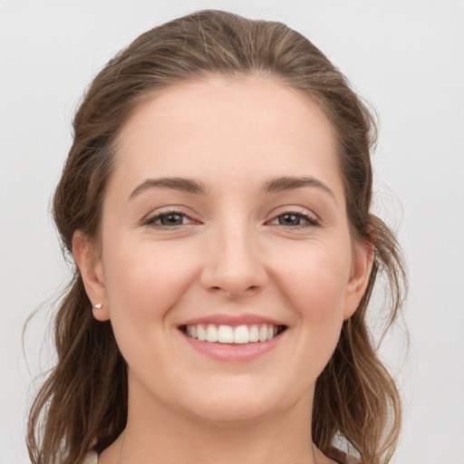 Joyful white young-adult female with medium  brown hair and grey eyes