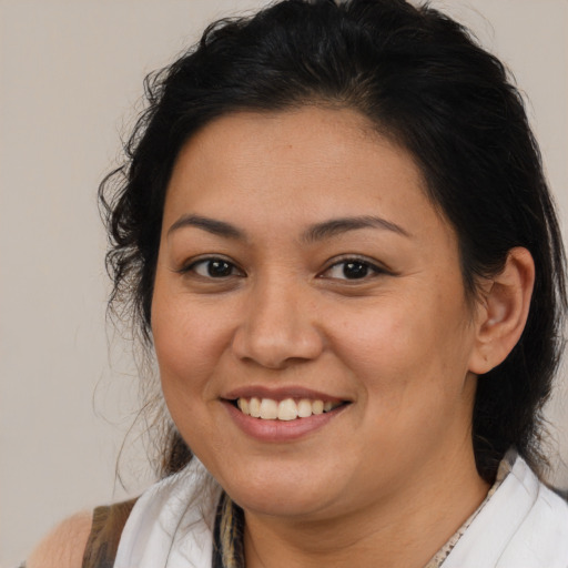 Joyful latino young-adult female with medium  brown hair and brown eyes