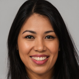 Joyful latino young-adult female with long  brown hair and brown eyes