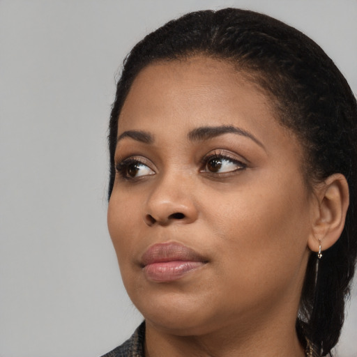 Joyful black young-adult female with long  brown hair and brown eyes