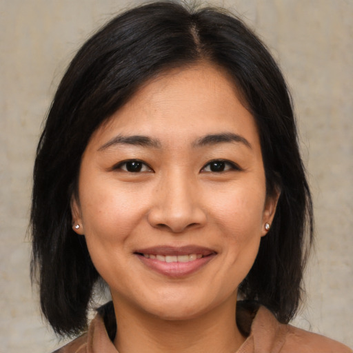 Joyful asian young-adult female with medium  brown hair and brown eyes