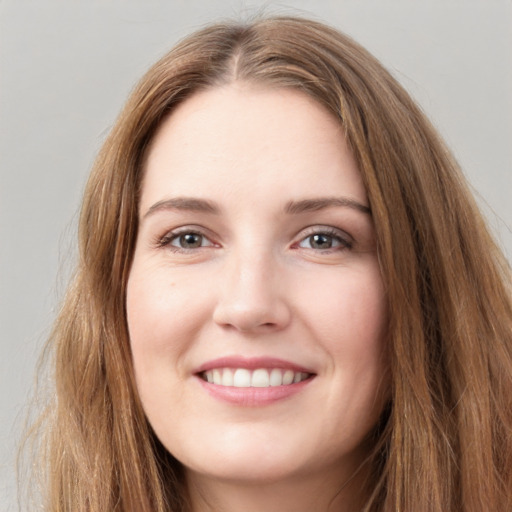 Joyful white young-adult female with long  brown hair and green eyes