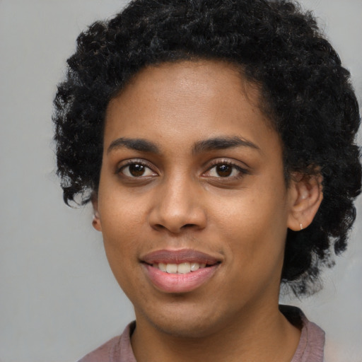 Joyful black young-adult female with short  black hair and brown eyes