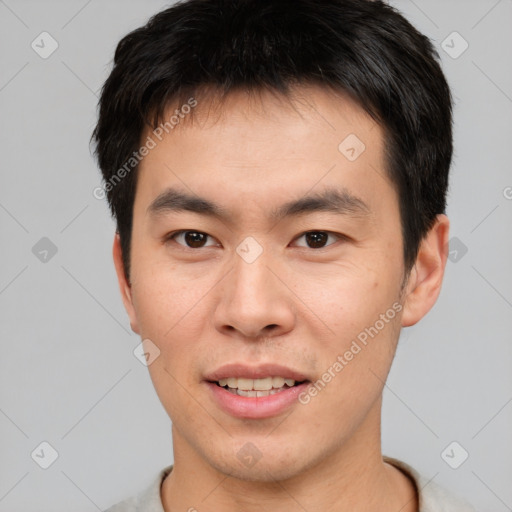 Joyful asian young-adult male with short  brown hair and brown eyes