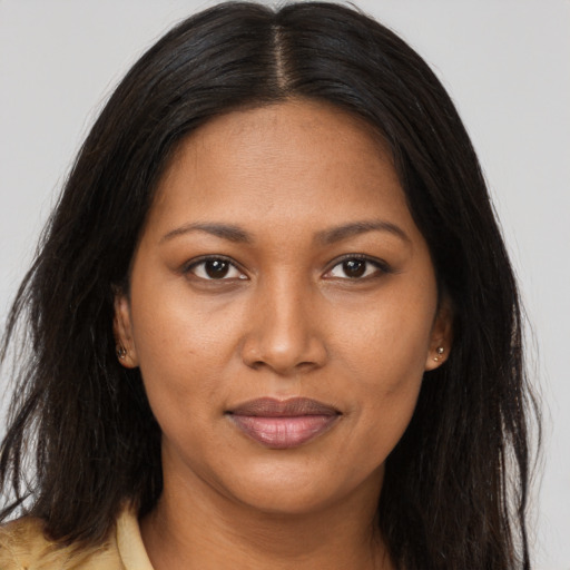 Joyful black adult female with long  brown hair and brown eyes