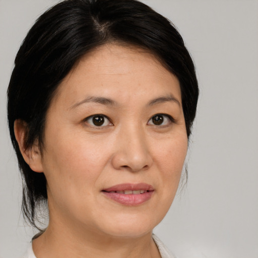 Joyful asian adult female with medium  brown hair and brown eyes