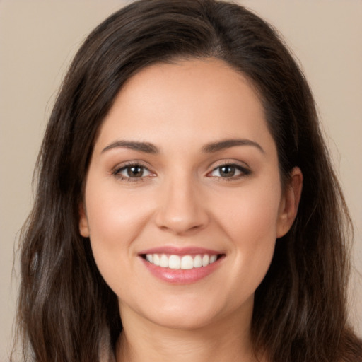 Joyful white young-adult female with long  brown hair and brown eyes