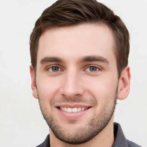 Joyful white young-adult male with short  brown hair and grey eyes