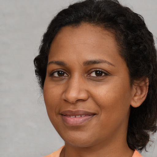 Joyful black young-adult female with medium  brown hair and brown eyes