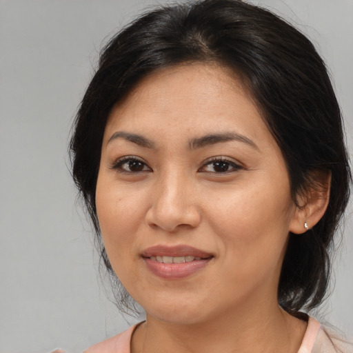 Joyful latino adult female with medium  brown hair and brown eyes