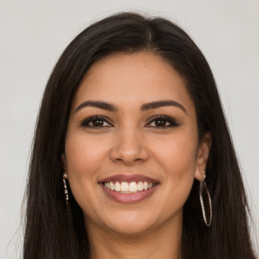 Joyful latino young-adult female with long  brown hair and brown eyes