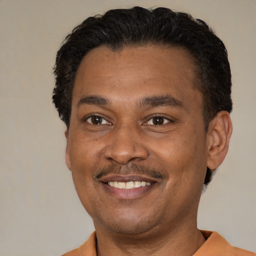 Joyful latino adult male with short  black hair and brown eyes