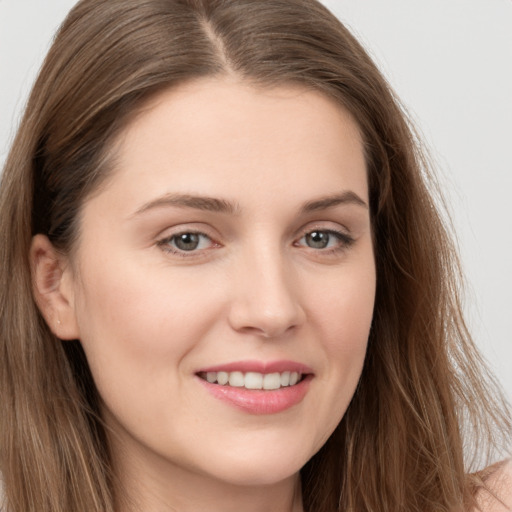 Joyful white young-adult female with long  brown hair and grey eyes