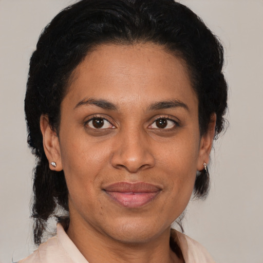 Joyful latino adult female with medium  brown hair and brown eyes