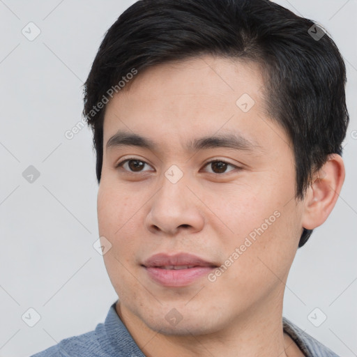 Joyful asian young-adult male with short  brown hair and brown eyes