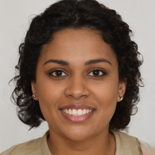 Joyful black young-adult female with long  brown hair and brown eyes