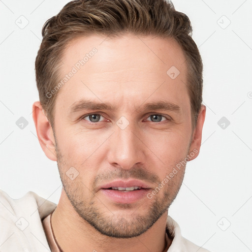 Joyful white young-adult male with short  brown hair and grey eyes