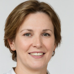 Joyful white adult female with medium  brown hair and grey eyes