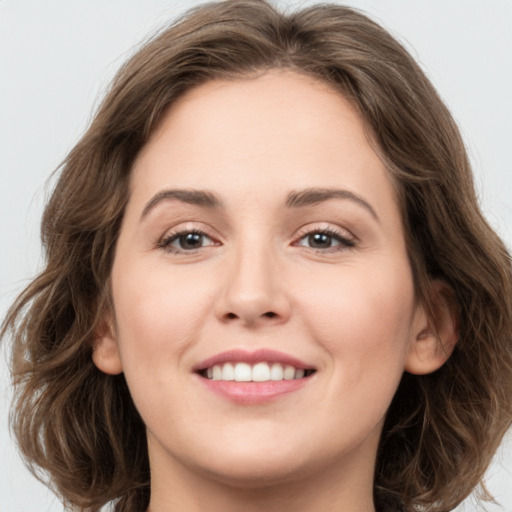 Joyful white young-adult female with medium  brown hair and green eyes