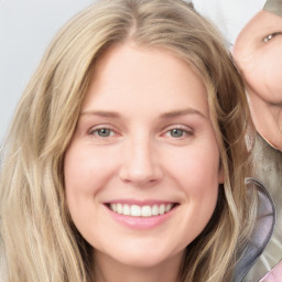 Joyful white young-adult female with long  brown hair and blue eyes