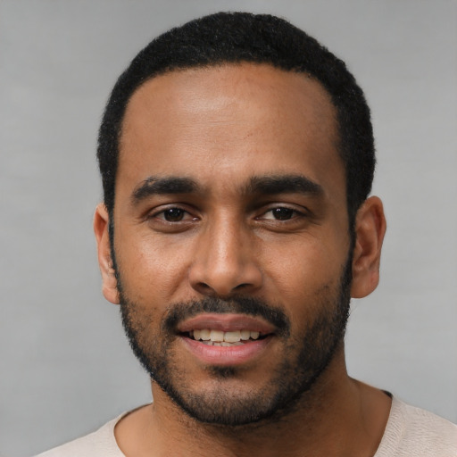 Joyful black young-adult male with short  black hair and brown eyes