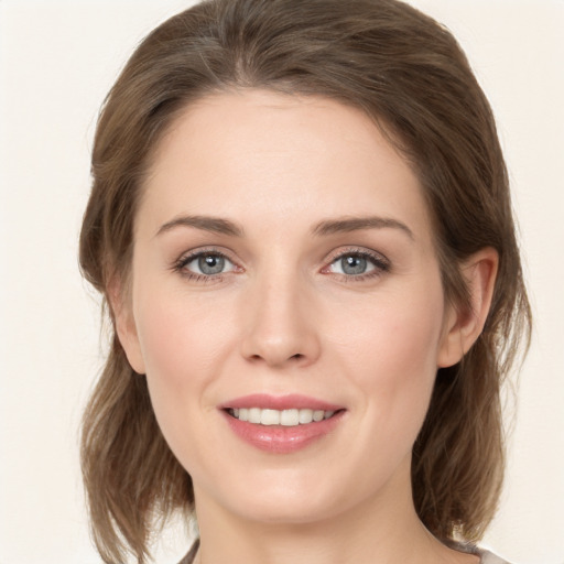 Joyful white young-adult female with medium  brown hair and grey eyes