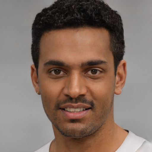 Joyful latino young-adult male with short  black hair and brown eyes