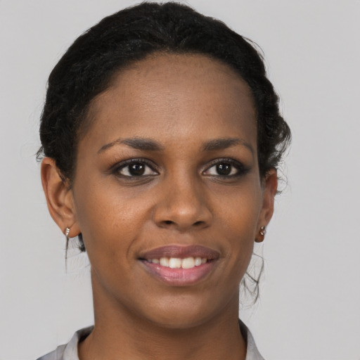 Joyful black young-adult female with short  brown hair and brown eyes