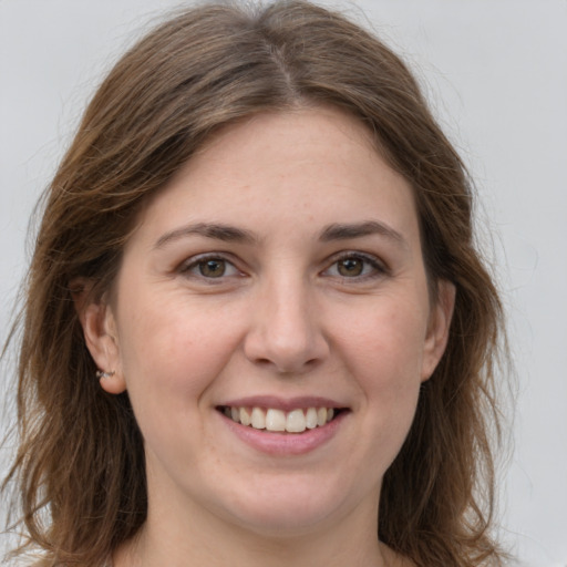 Joyful white young-adult female with long  brown hair and grey eyes