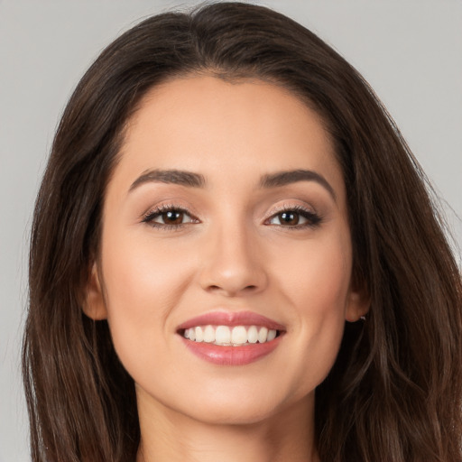 Joyful white young-adult female with long  brown hair and brown eyes