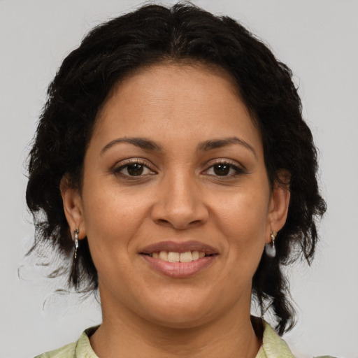 Joyful latino adult female with medium  brown hair and brown eyes